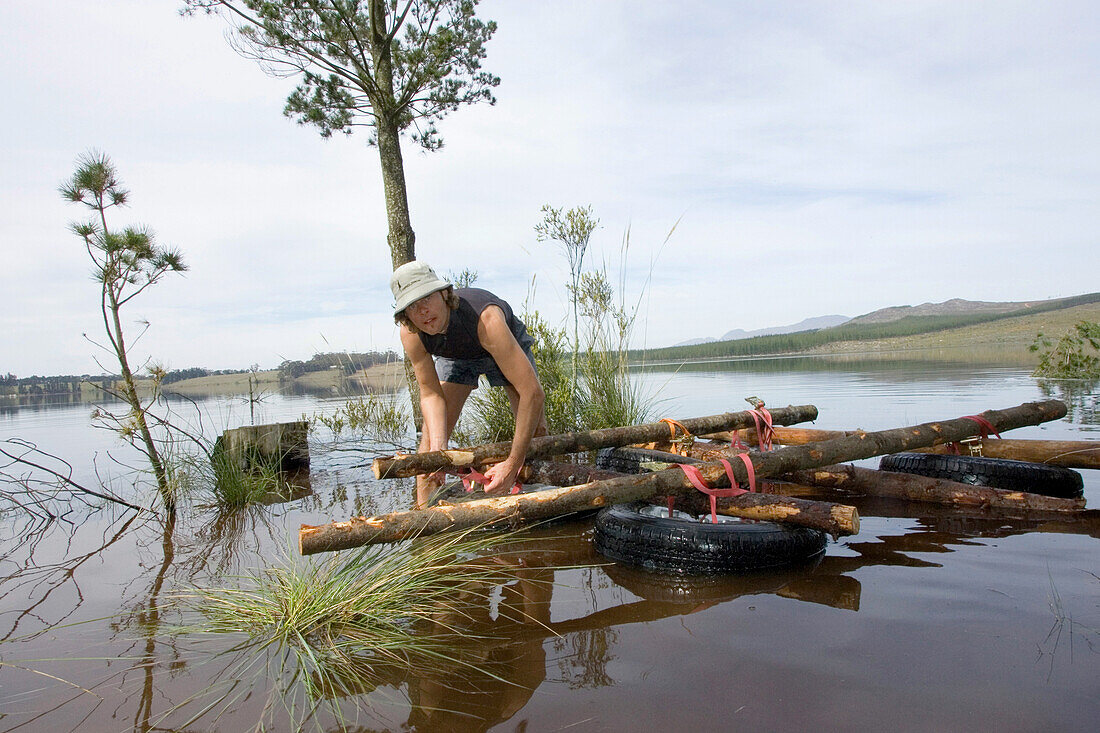 Man building a raft in water, Grabouw Forest Park, near Cape Town, South Africa, Africa, mr