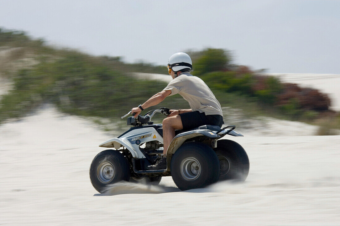 Man driving a quad up sand dunes, Atlantis Sand Dunes, South Africa, Africa, mr