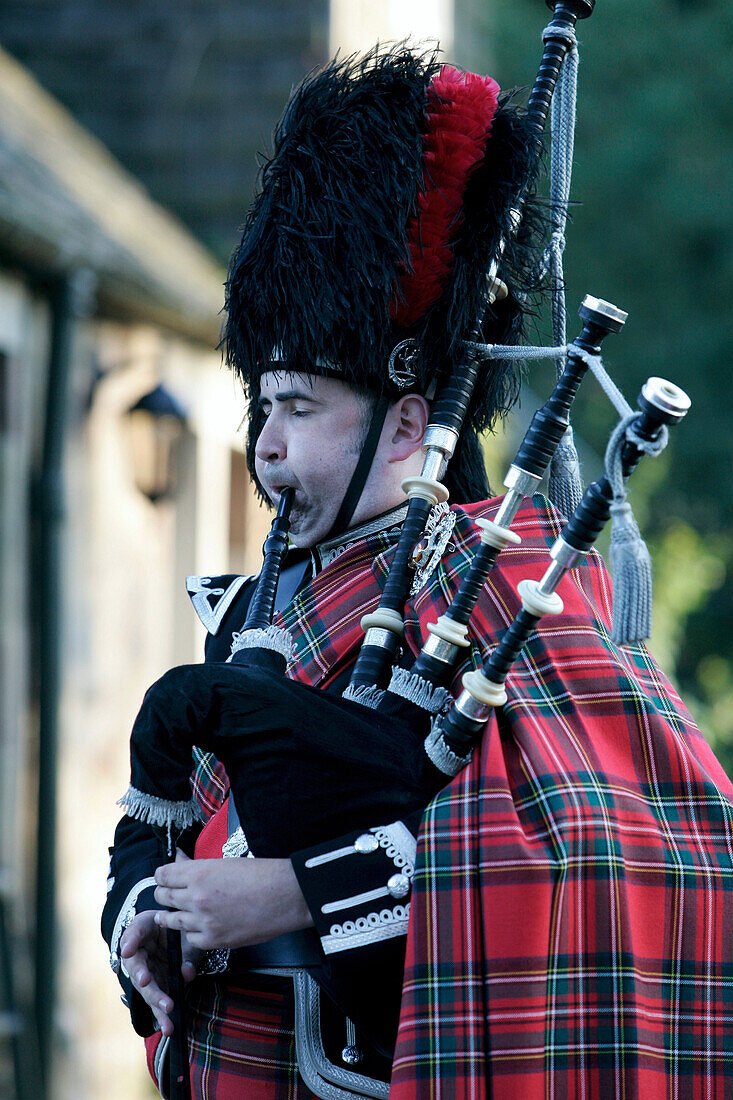 Ein Dudelsackspieler, Schotte im Kilt mit Dudelsack, Schottisches Hochland, Schottland, Großbritannien, Europa