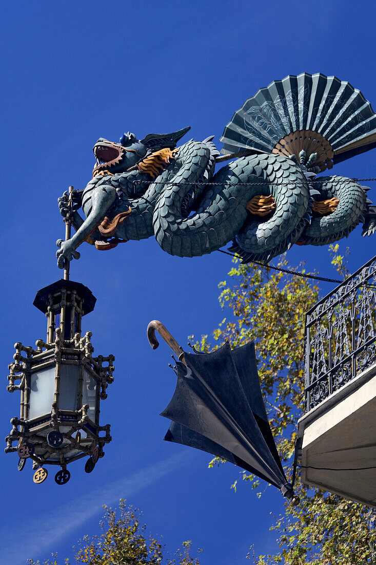 Barcelona,Ramblas,Art Deco dragon with laterne,umbrella shop hanging on a house fassade