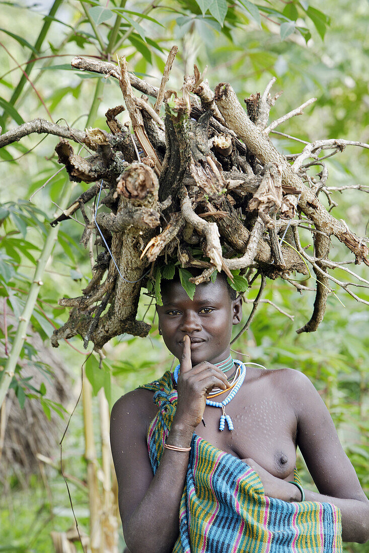 Surma woman carrying wood. Near Kibish. Ethiopia.