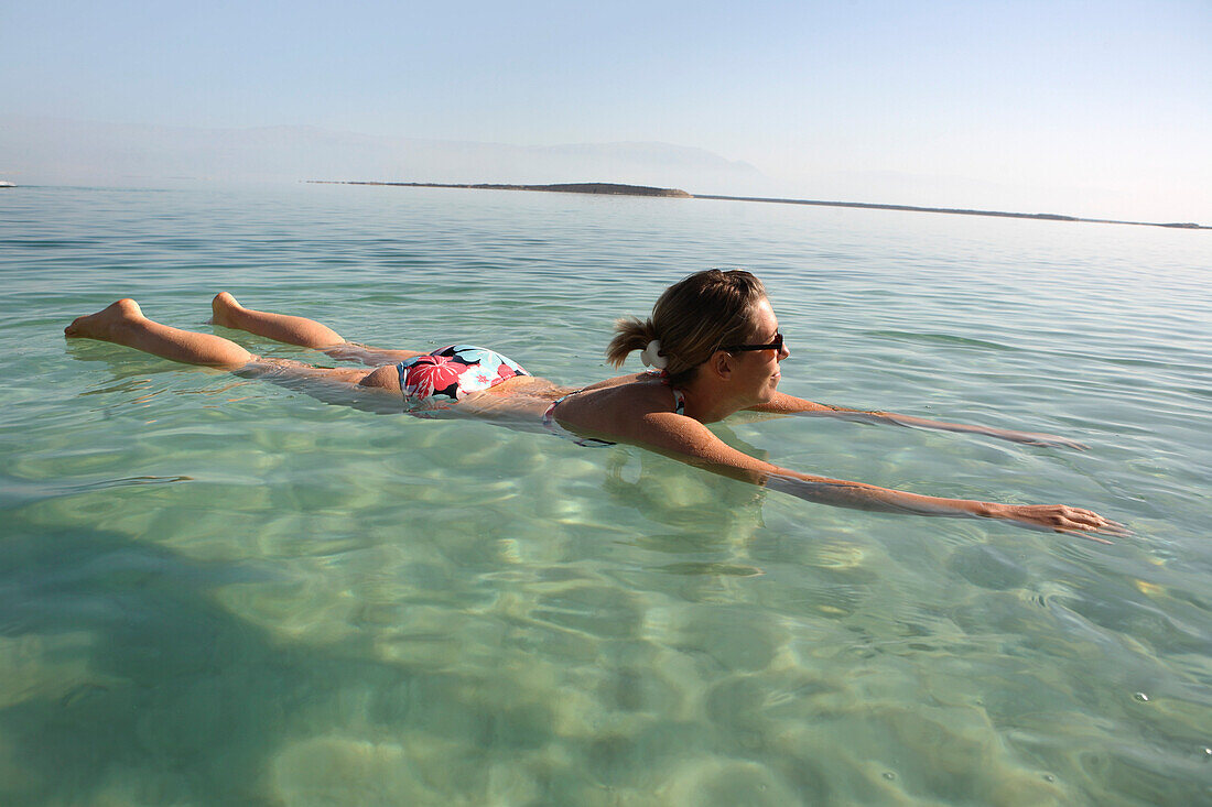Woman floating in the Dead Sea, Ein Bokek, Israel