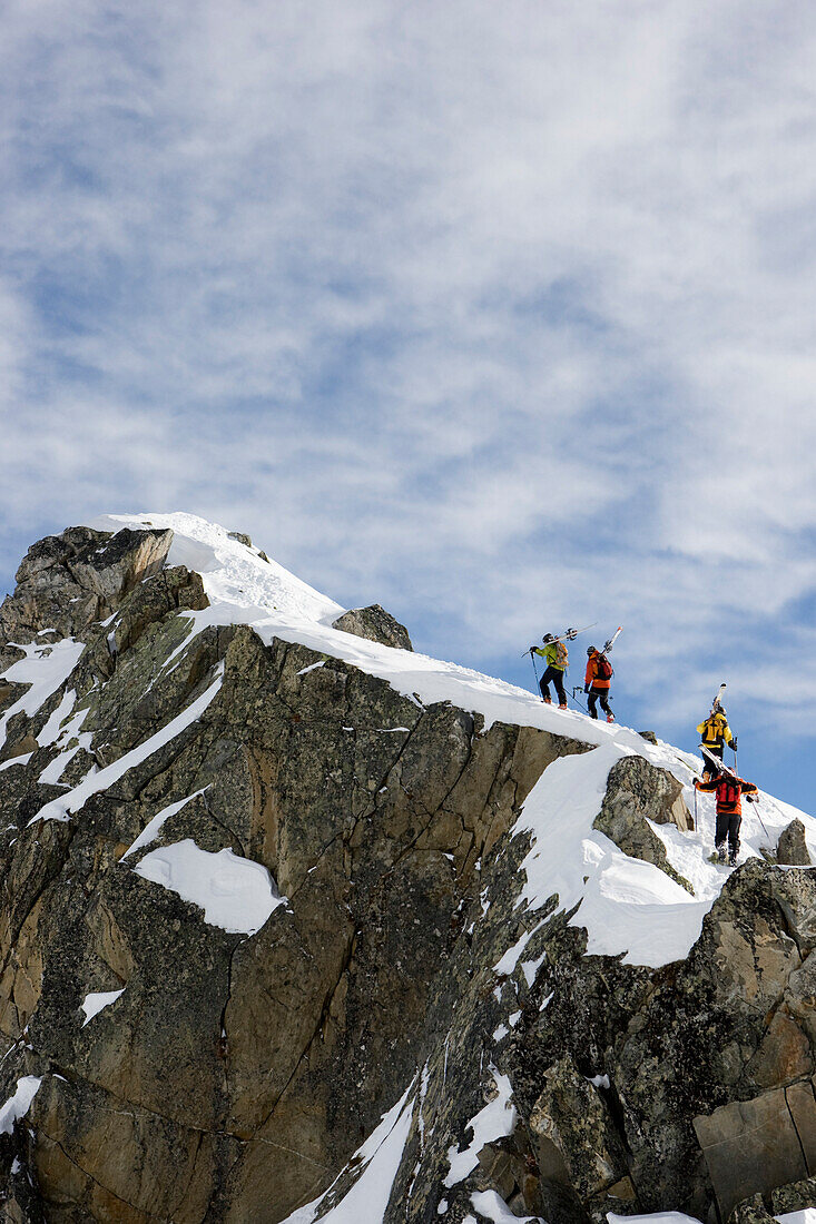 Group of freerider carrying skies on mount La Muota, Disentis, Grisons, Switzerland