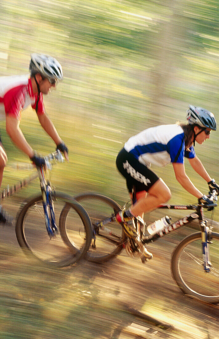 Mountain biker riding fast in forest at Deer Valley. Utah, USA