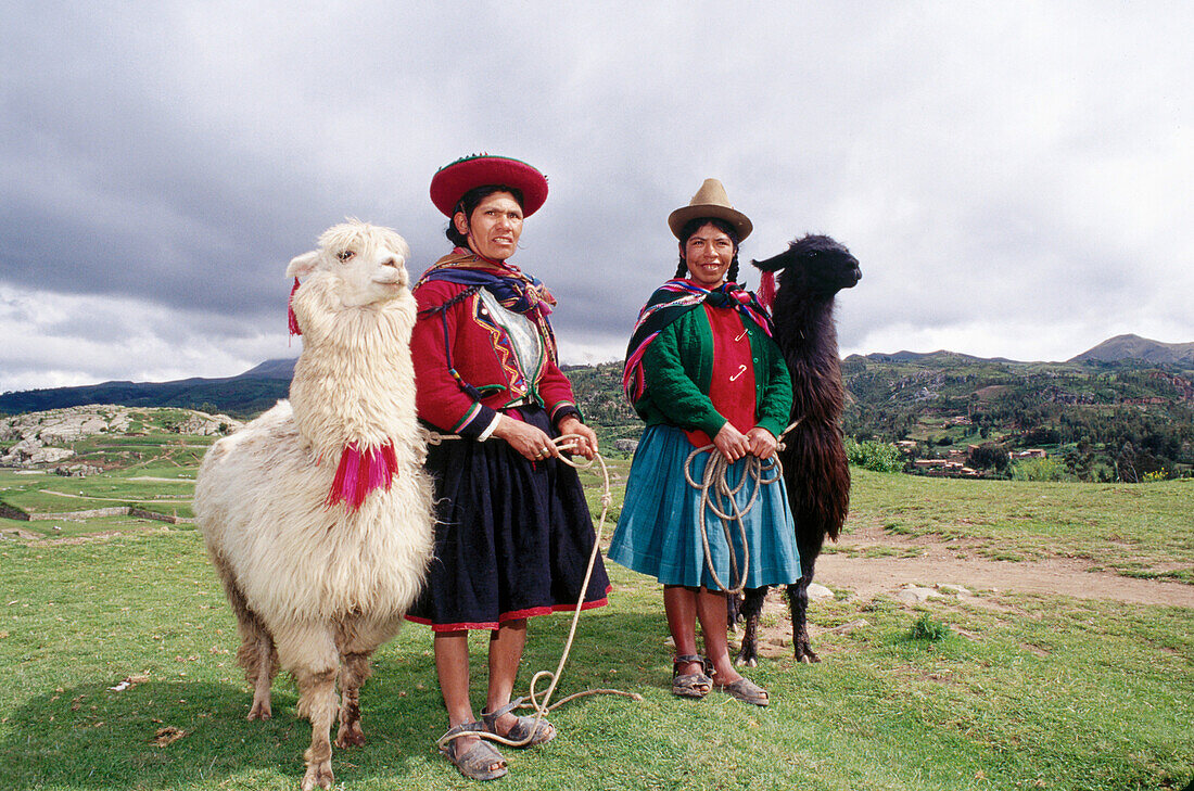 Quechua women in traditional costumes with their llamas. Peru
