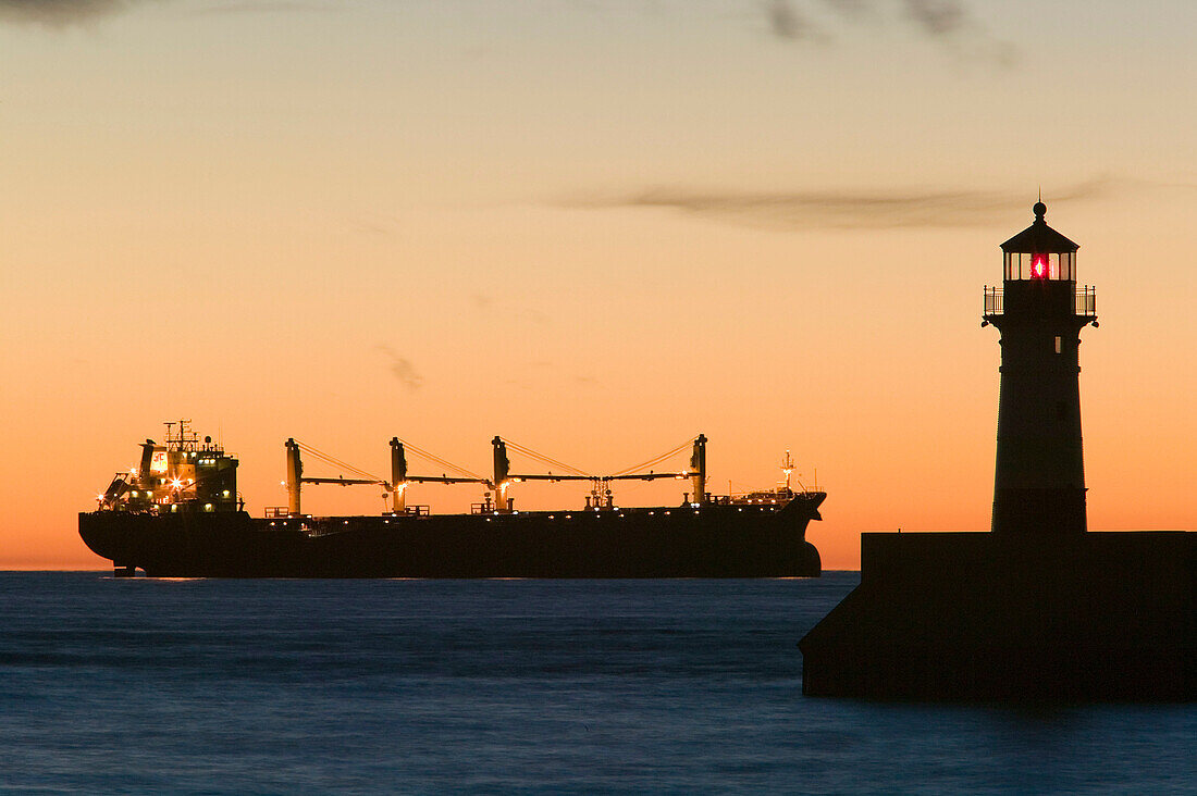 Duluth Harbor. Shipping Channel Lighthouse at Dawn with Freighter. Duluth. Minnesota. USA.