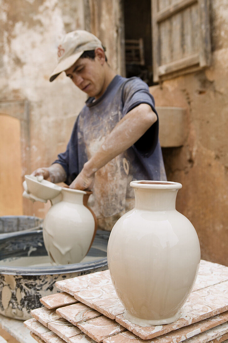 Morocco. Atlantic Coast. Safi:Colline des Potiers.Potter s Hill. Artisan preparing pottery for glazing.