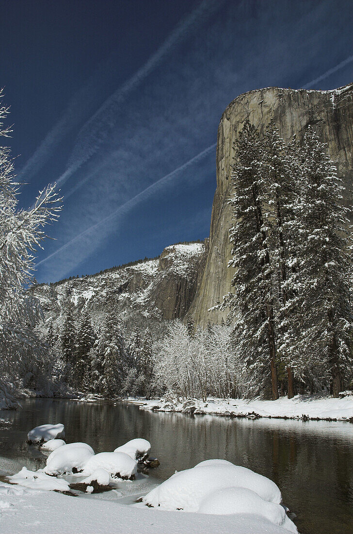 The rock face of El Capitan and the Merced River after a winter snow storm, (aircraft vapour trails in the sky), Yosemite Valley, Yosemite NationalPark, California, USA.
