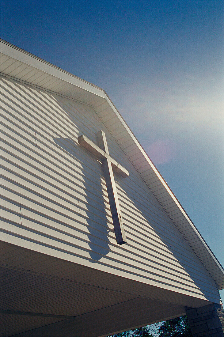 Cross on front of rural Christian church, sunlit, Monroe County, Indiana, USA