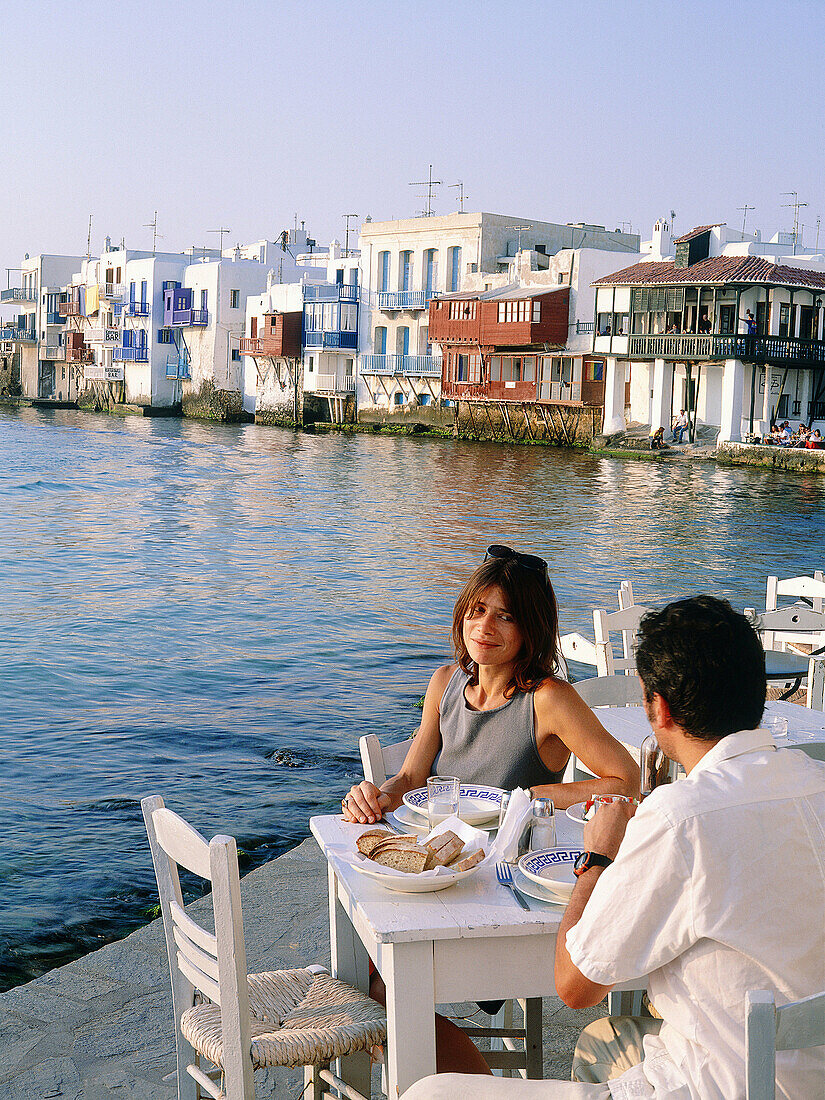 Greece, Cyclades Islands, Mykonos. Having a diner at Sunset, Little Venice in background