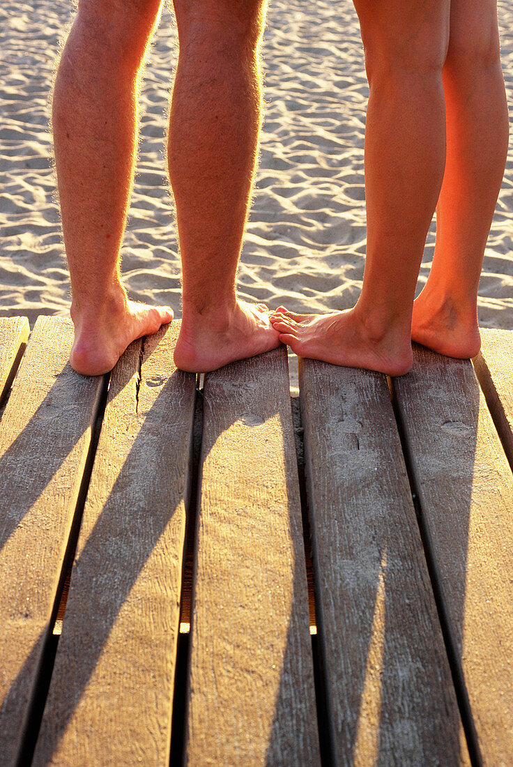 Couple s feet together at beach boardwalk