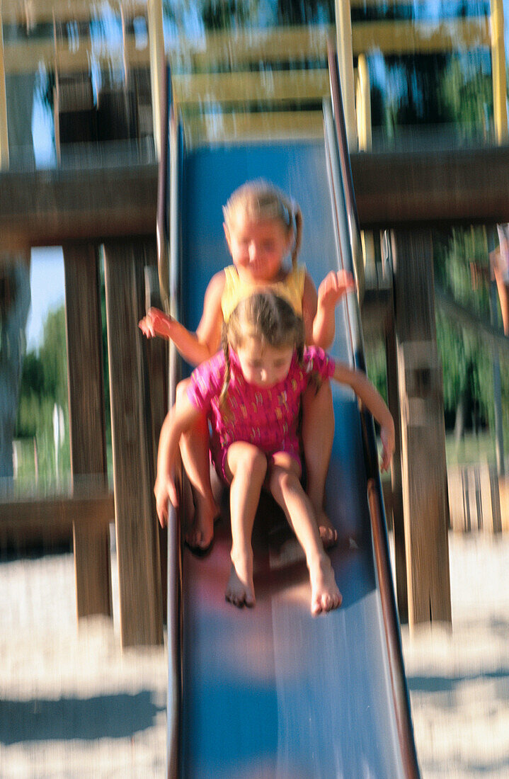 Girls sliding down slide