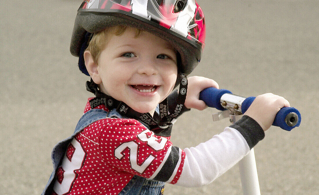 Boy with bike helmet and scooter