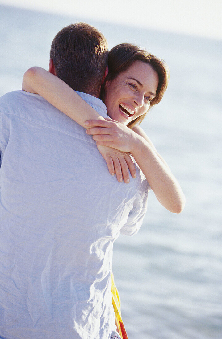 s, Back view, Beach, Beaches, Bond, Bonding, Bonds, Brunette, Brunettes, Caucasian, Caucasians, Closed eyes, Coast, Coastal, Color, Colour, Contemporary, Couple, Couples, Dark-haired, Daytime, Embrace