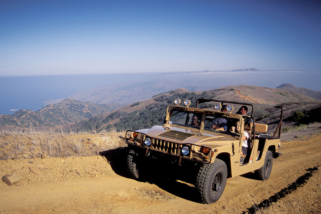 Hummer SUV transportation vehicle takes tourists on driving tour through hills of Catalina Island, California Coast. USA