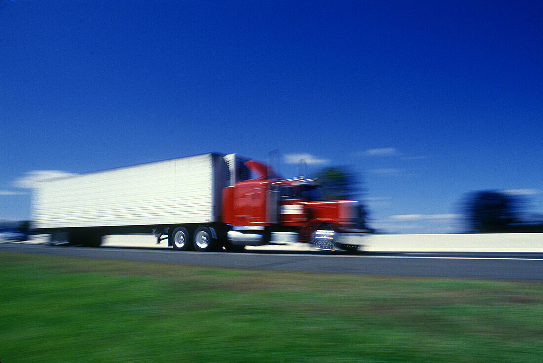  Blurred, Color, Colour, Daytime, Economy, Exterior, Fast, Freight transportation, Highway, Highways, Industrial, Industry, Lorries, Lorry, Motion, Movement, Moving, Outdoor, Outdoors, Outside, Road, Roads, Shipping, Speed, Thoroughfare, Thoroughfares, Tr