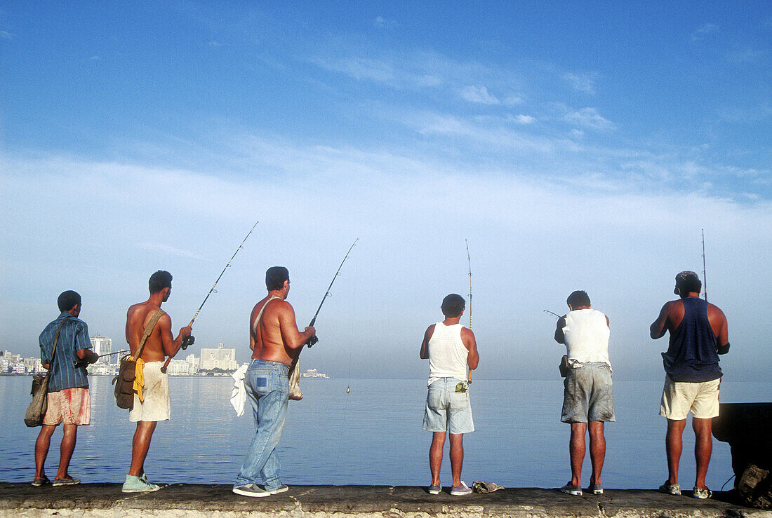 Men fishing off sea wall. Malecon. Havana. Cuba