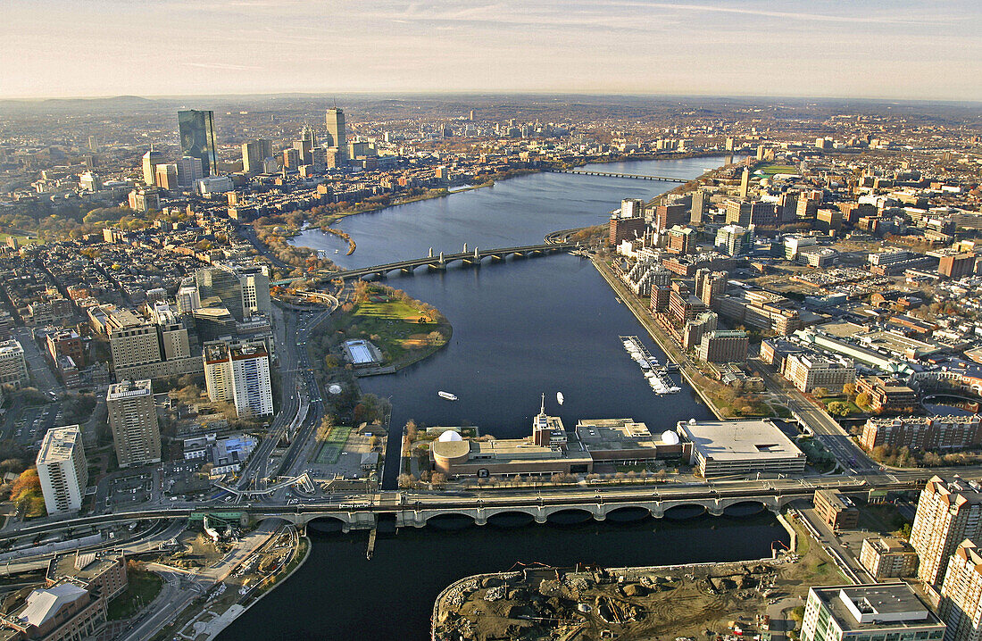 Charles River dividing Boston (on left) and Cambridge (on right) with Museum of Science in foreground and Longfellow Bridge behind. Harvard Bridge is in the distance. Massachusetts. USA.