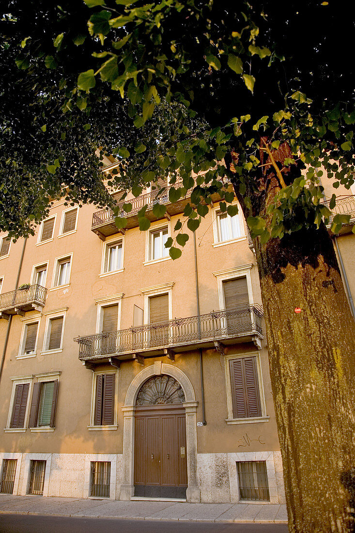 apartment building with arched doorway, balconies and shutters in Verona, Italy