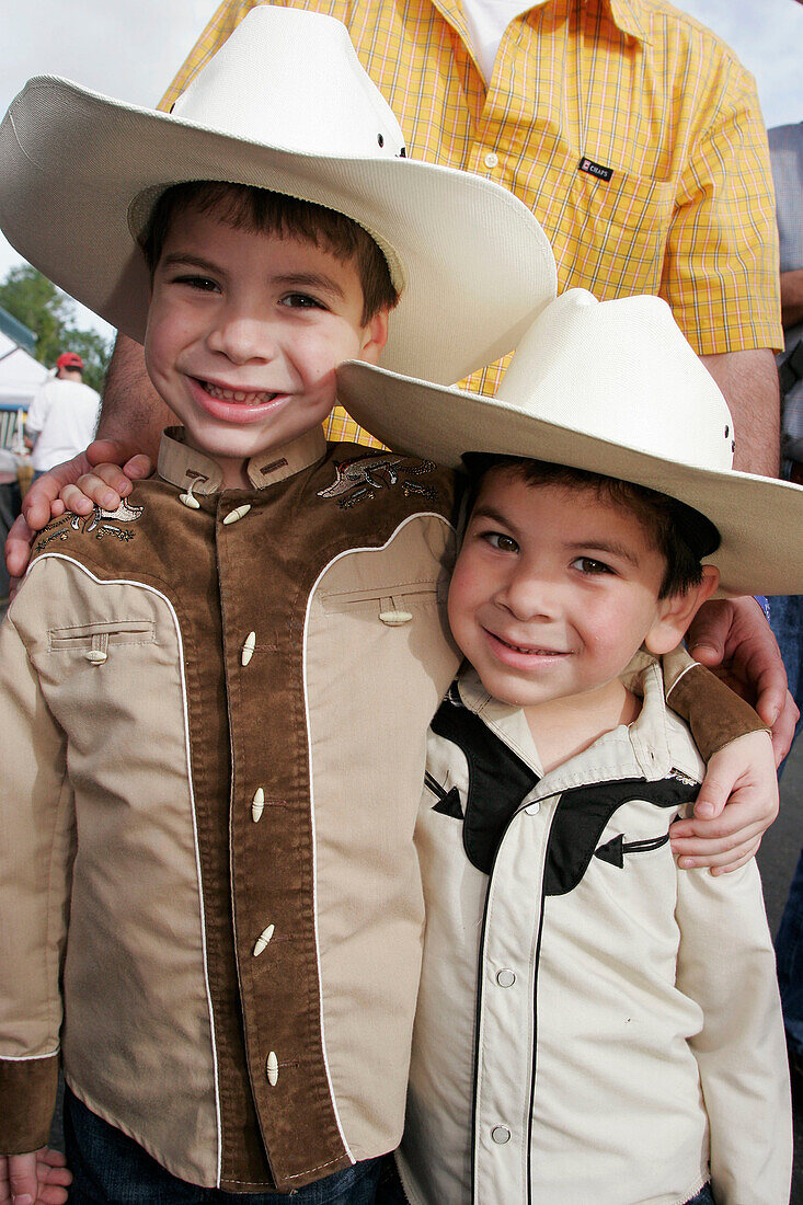 Hispanic boys, brothers, cowboy outfit, hat. Championship Rodeo. Homestead. Florida. USA.