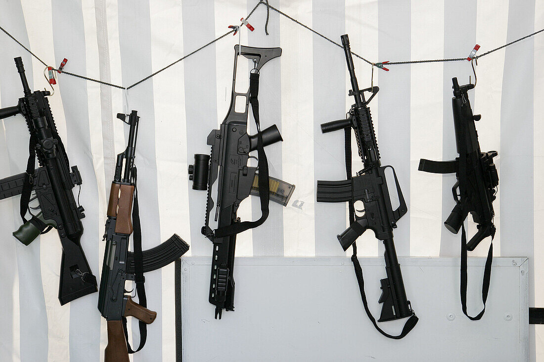 Fake automaic rifles, portrait props, weapon. Annual Hispanic festival. Calle Ocho. Little Havana. Miami. Florida. USA.