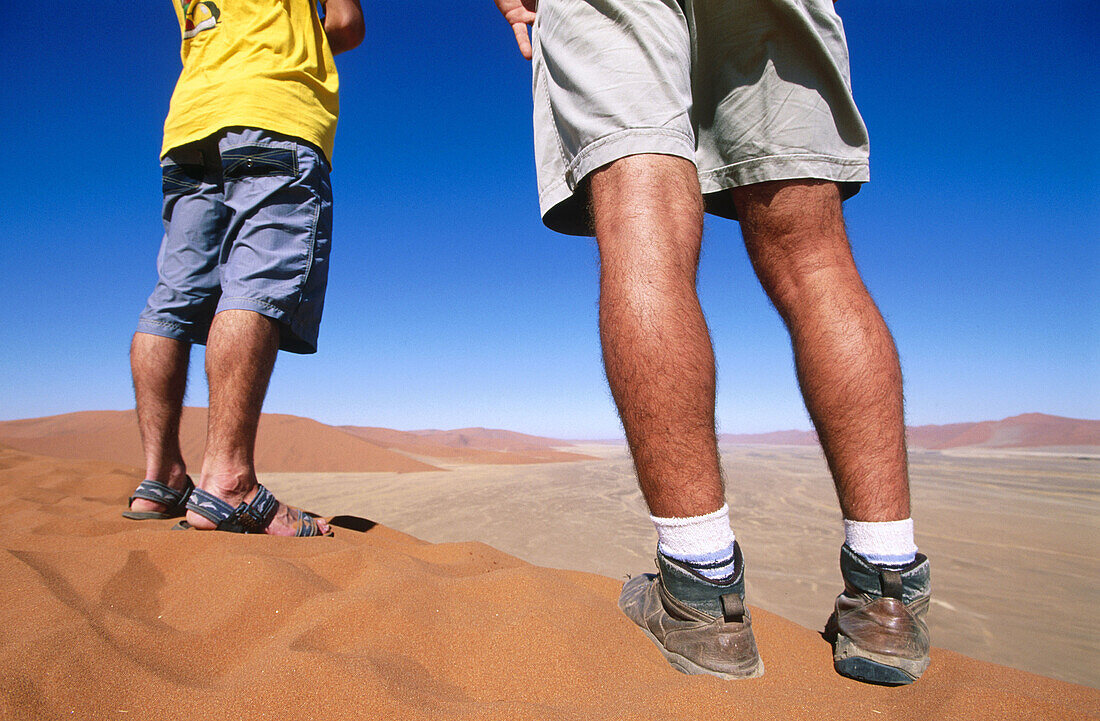 Men standing on a dune. Sossusvlei. Namib Desert