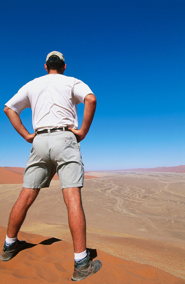  Africa, Arid, Aridity, Back view, Barren, Blue, Blue sky, Color, Colour, Daytime, Desert, Deserts, Dry, Dune, Dunes, Exterior, Full-body, Full-length, Human, Male, Man, Men, Men only, Namibia, Nature, One, One person, Outdoor, Outdoors, Outside, People, 