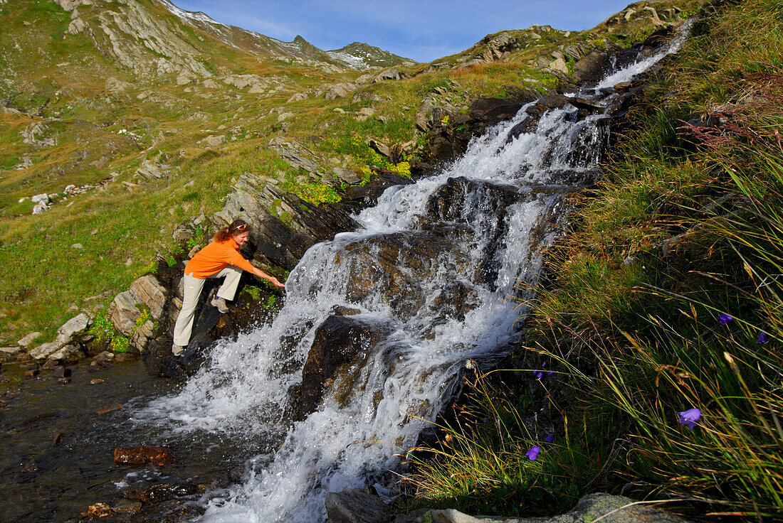 young woman at waterfall, Lago del Naret (Lago del Narèt), Ticino, Switzerland