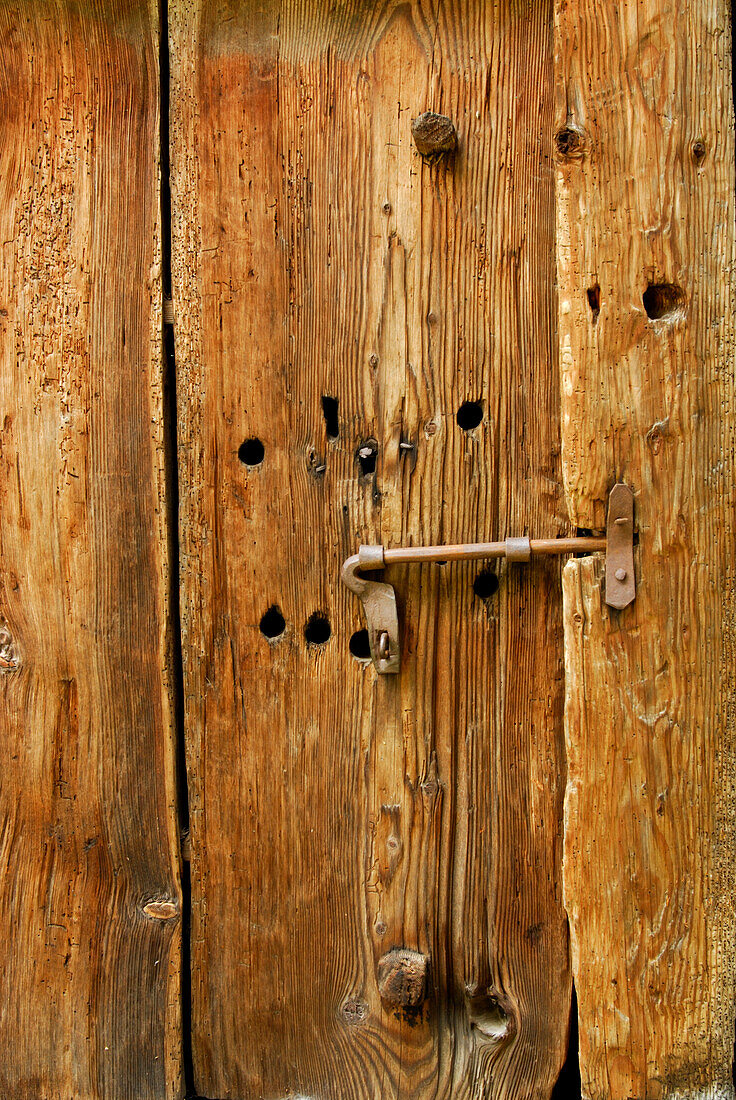 wooden door of haystack with lock bar, Rossa, Val Calanca, Ticino, Switzerland