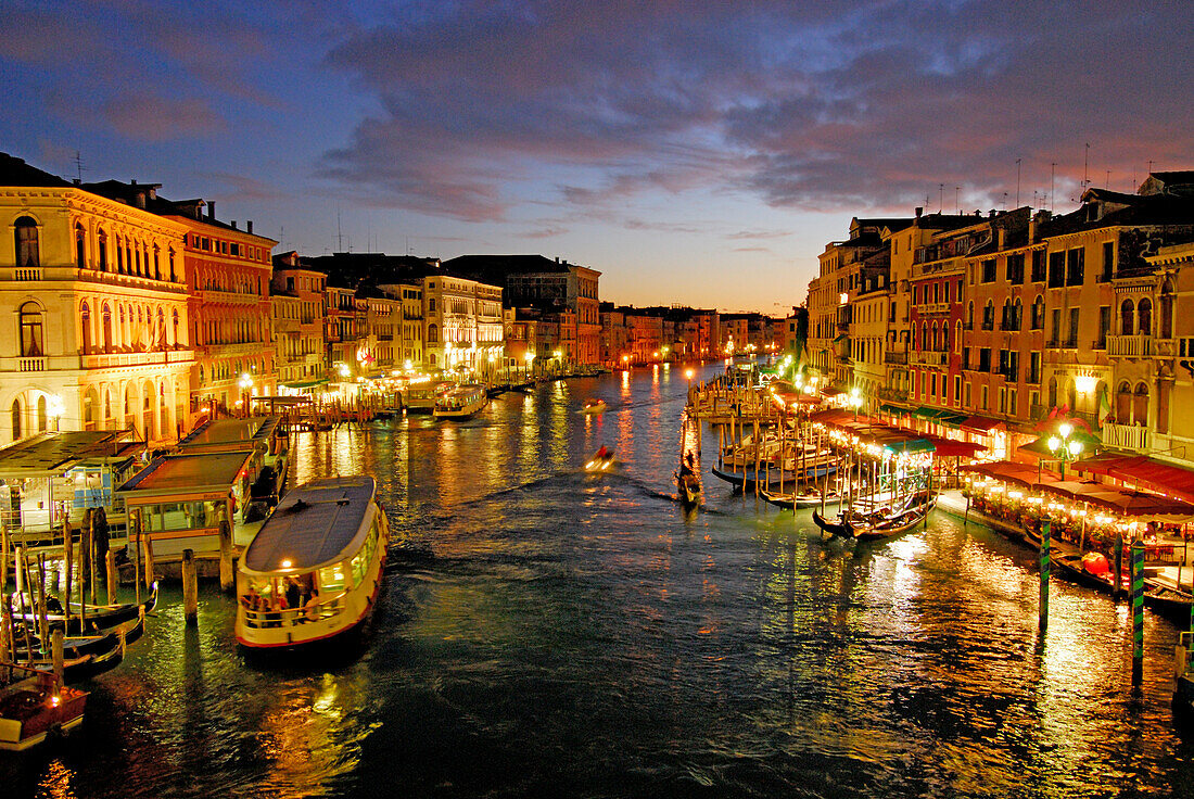 Canal Grande mit beleuchteten Häusern und Restaurants in der Abenddämmerung, Venedig, Venezien, Italien