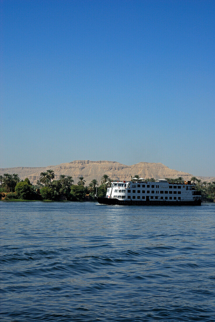 Kreuzfahrtschiff auf dem Nil und Palmen am Westufer, Luxor, Ägypten, Afrika