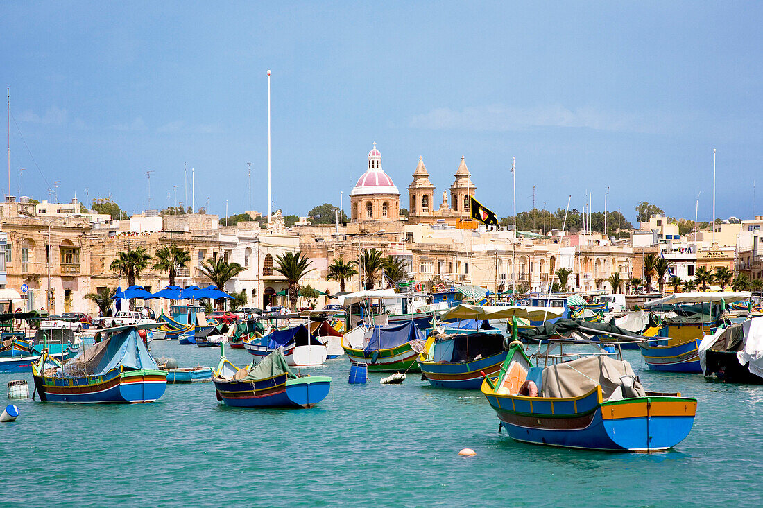 Boats at harbour in front of the church of Marsaxlokk, Malta, Europe