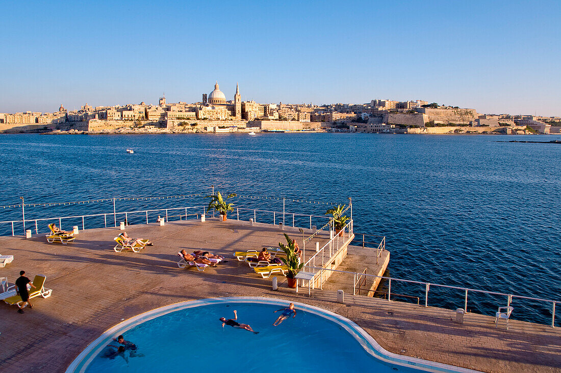 Blick über einen Pool am Wasser auf die Stadt Valletta, Sliema, Malta, Europa