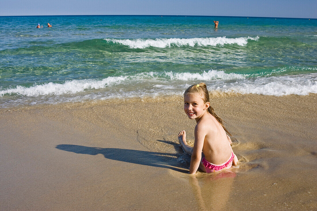 Kleines Mädchen spielt am Strand, Sardinien, Italien