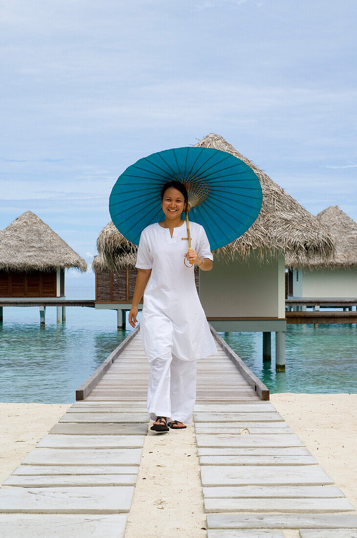 Frau, Spa Therapeutin mit Sonnenschirm, Spa Pavillon, Four Seasons Resort Landaa Giraavaru, Malediven