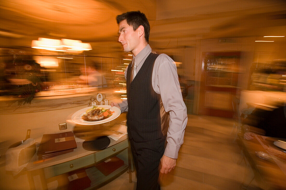 Kellner serviert Mahlzeit im Restaurant des Hotels Zugspitze, Garmisch-Partenkirchen, Oberbayern, Deutschland
