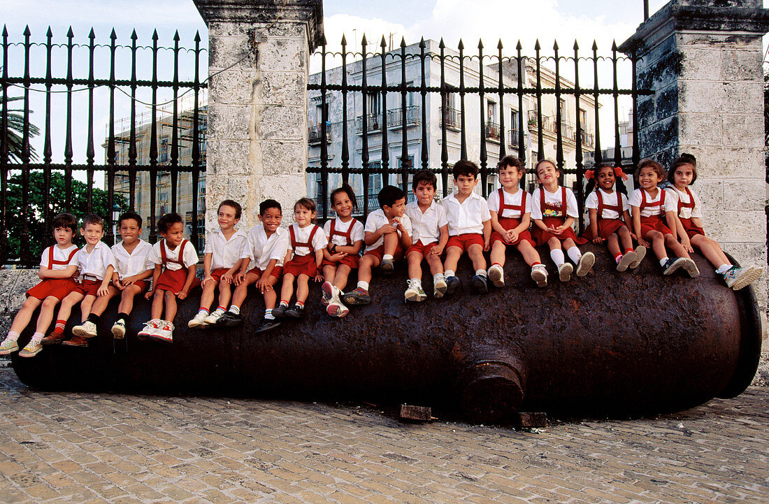 Schoolchildren on gun. Plaza de Armas. Havana. Cuba