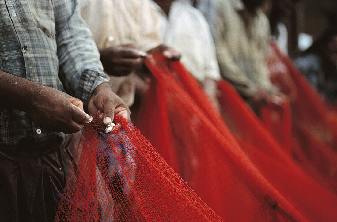 Fishermen fix nets. Kerala. India