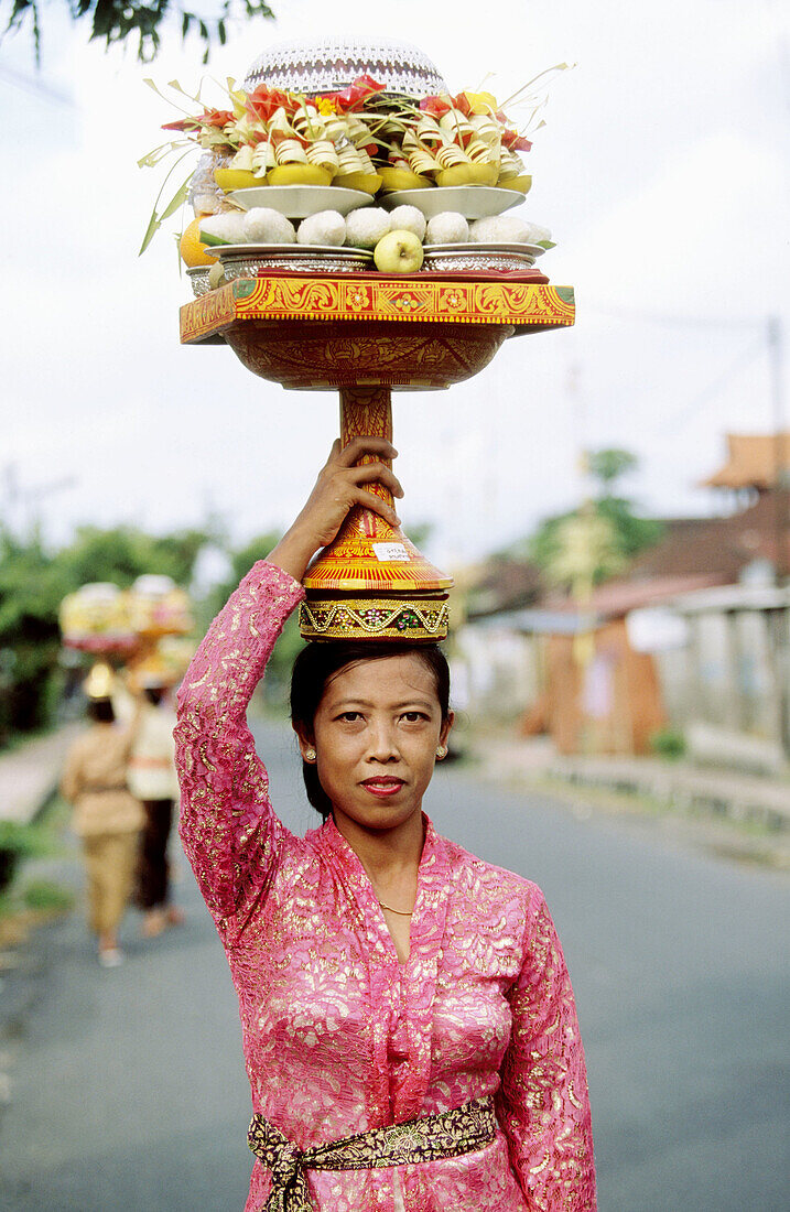 Woman carrying offers the Galungan Festival. Bali, Indonesia