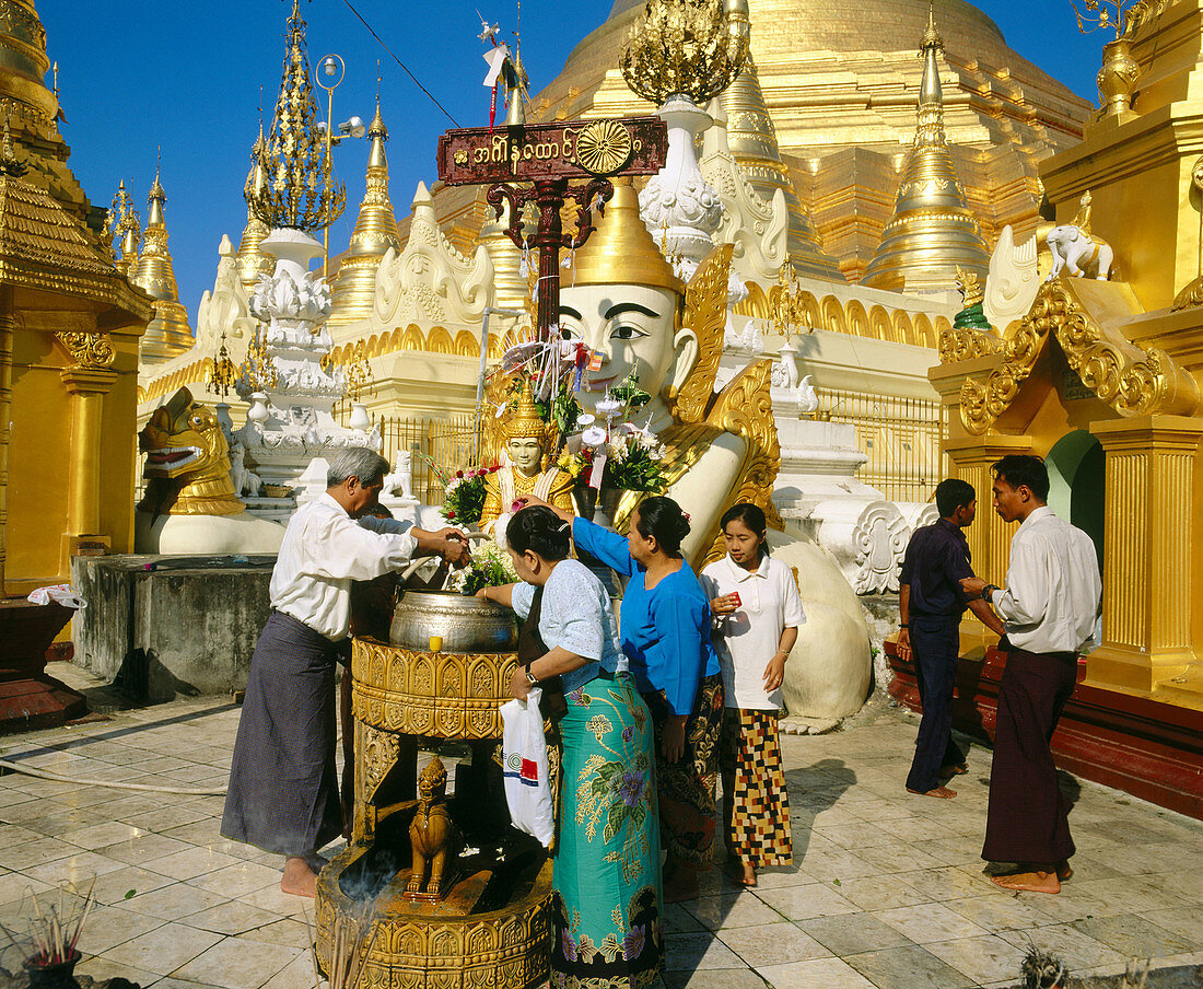 People doing a bouddhist ritual in the Shwedagon Pagoda. Yangoon. Myanmar
