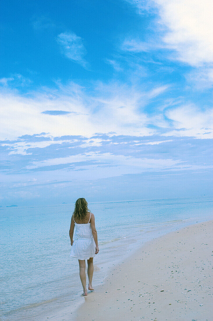  Adult, Adults, Alone, Back view, Beach, Beaches, Blue, Calm, Calmness, Chill out, Chilling out, Cloud, Clouds, Coast, Coastal, Color, Colour, Contemporary, Daytime, Exterior, Female, Full-body, Full-length, Holiday, Holidays, Human, Leisure, One, One per