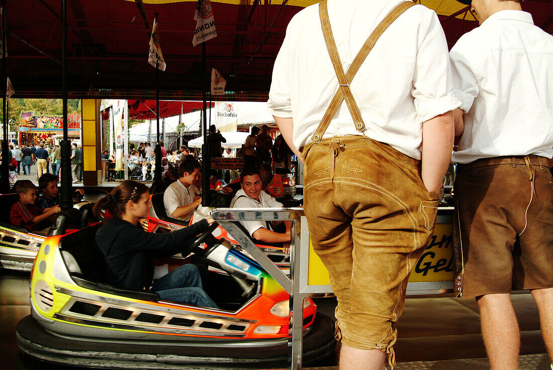 Young Bavarians watching bumper cars at fair. Regensburg. Bavaria, Germany