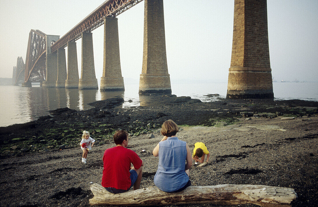Family by the Forth Bridge. Firth of Forth, near Edinburgh. Scotland