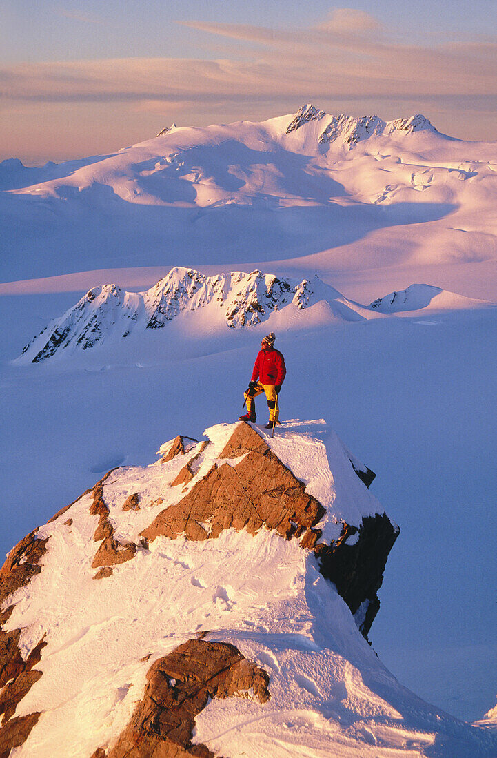 Climber on summit at sunset above Franz Josef Glacier. Westland National Park. New Zealand