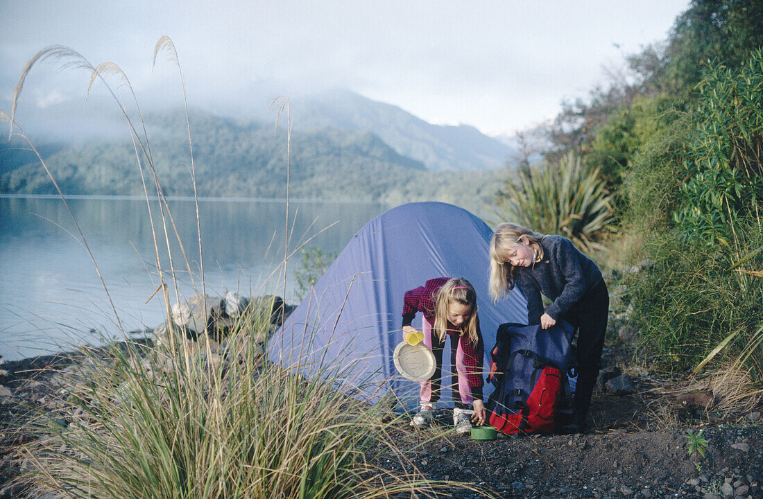 Children camping by lake Kaniere. West coast, South Island, New Zealand.