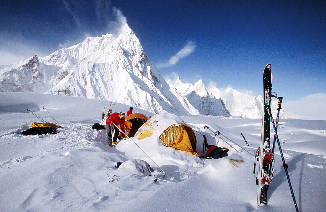Campsite under iced-up rock spires after storm on Baltoro glacier. Karakoram mountains, Pakistan