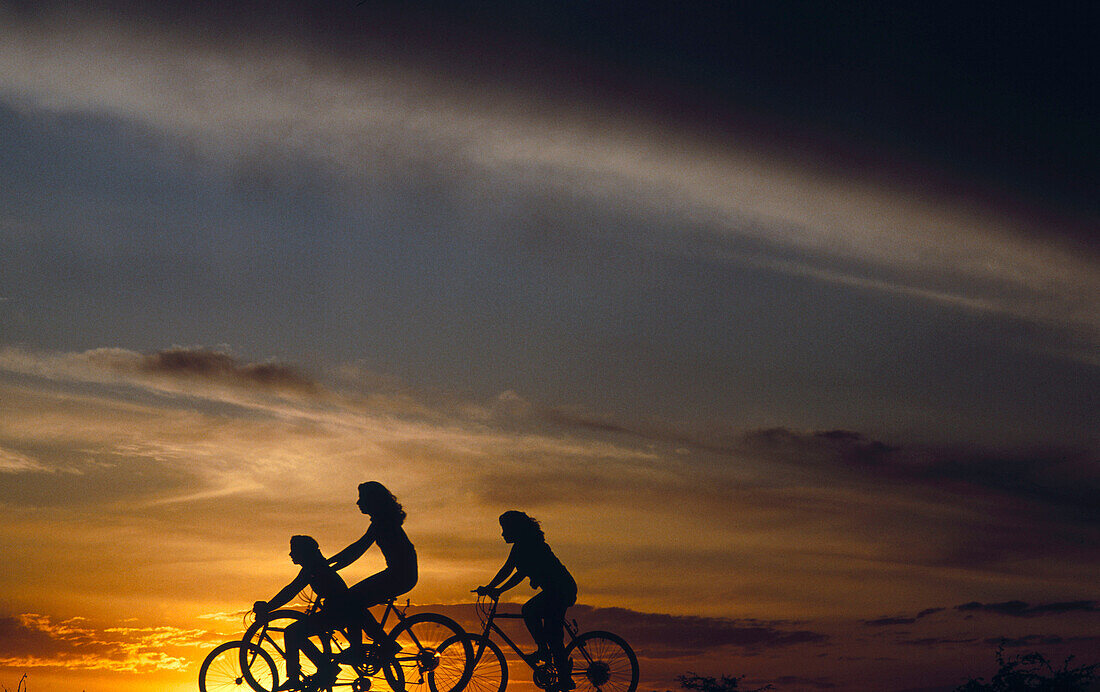 Girls riding bikes at sunset