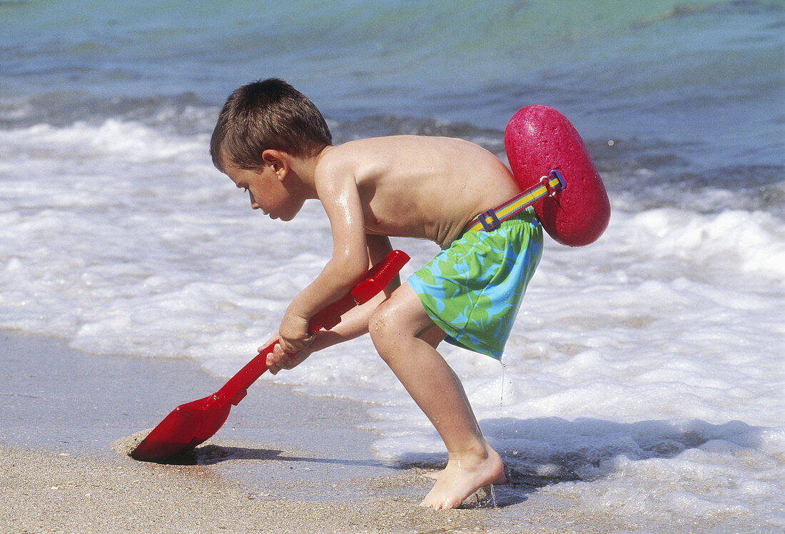 Boy with shovel at the beach