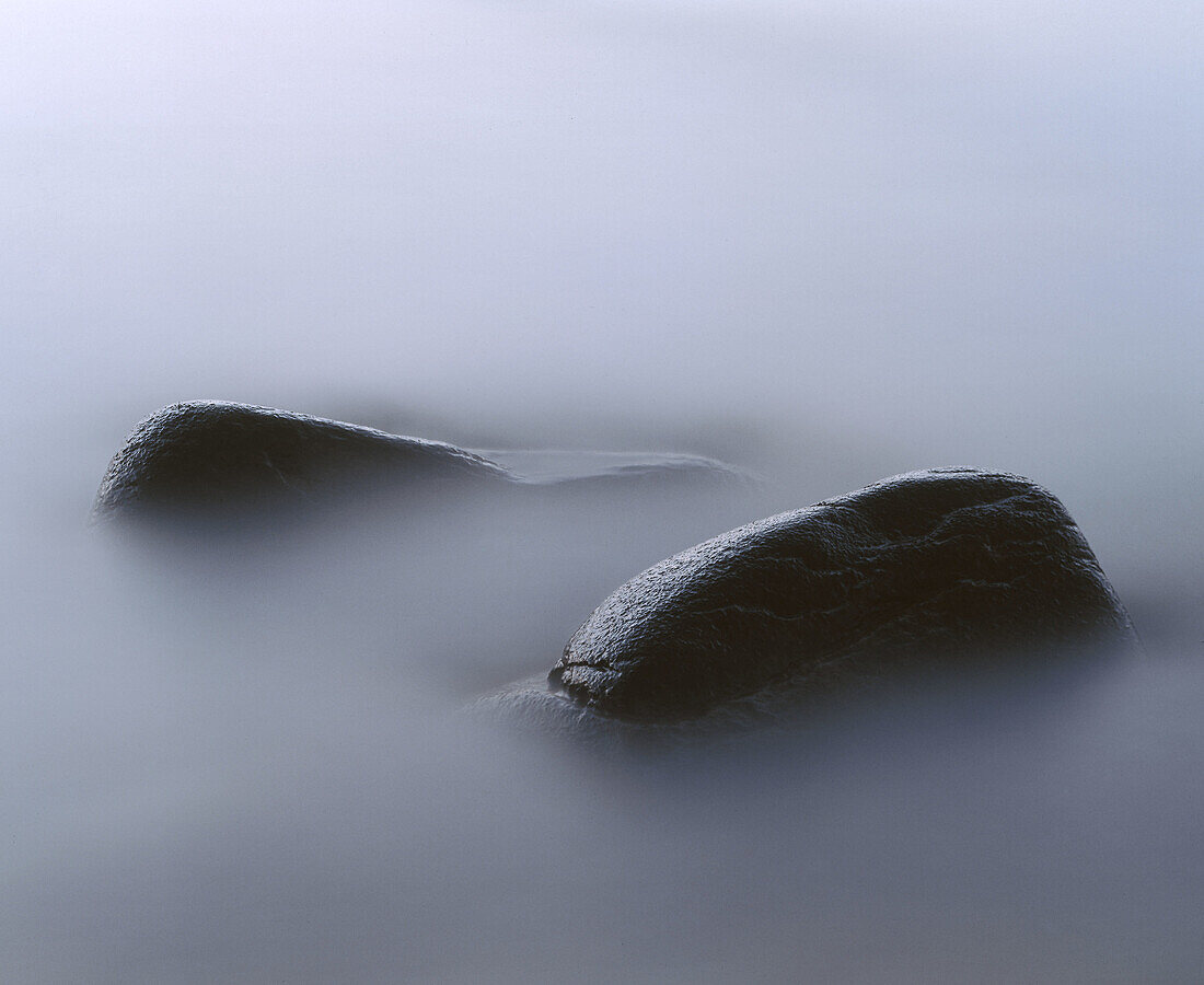 Stones in misty blue water. Hovs Hallar, Kattegatt Sea, Skåne, Sweden.