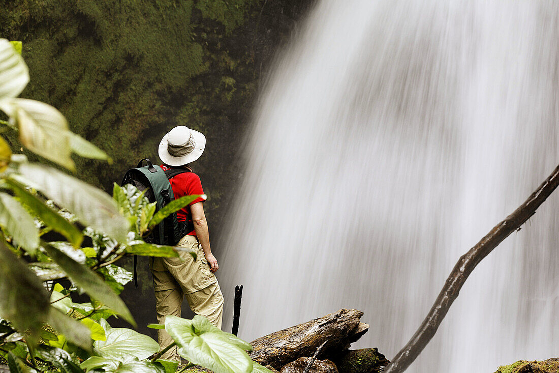 Woman at waterfall in private reserve Arenal Observatory Lodge, Arenal region, Costa Rica